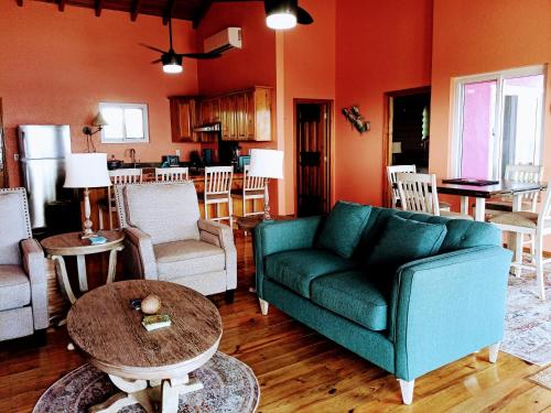 ein Wohnzimmer mit einem Sofa und einem Tisch in der Unterkunft Casa Corazon Striking Beach Home in Utila