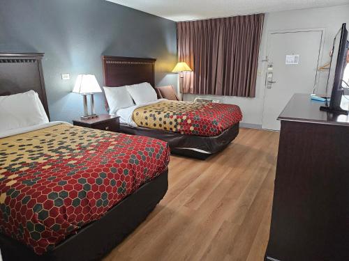a hotel room with two beds and a television at Econo Lodge Biltmore in Asheville