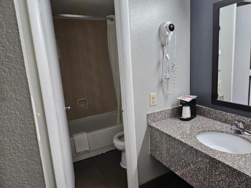 y baño con lavabo, aseo y espejo. en Econo Lodge Biltmore en Asheville