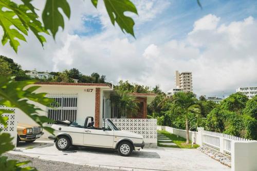 a white car parked in front of a house at Mid-Century House YOGI in Okinawa City