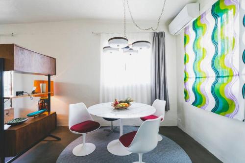 a dining room with a white table and chairs at Mid-Century House YOGI in Okinawa City