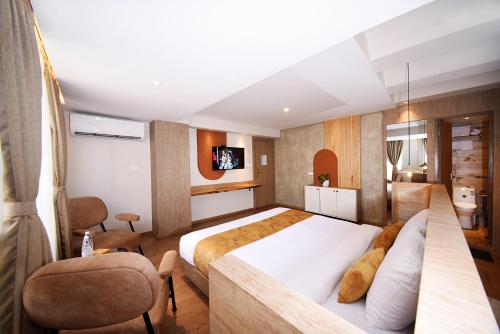 カトマンズにあるDaali Hotel & Apartmentのベッドとテレビが備わるホテルルームです。