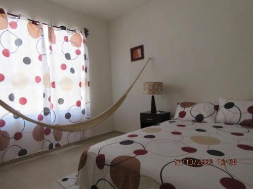 Un dormitorio con una cama con una manta de flores y una ventana en Casa Turquesa, en Cancún
