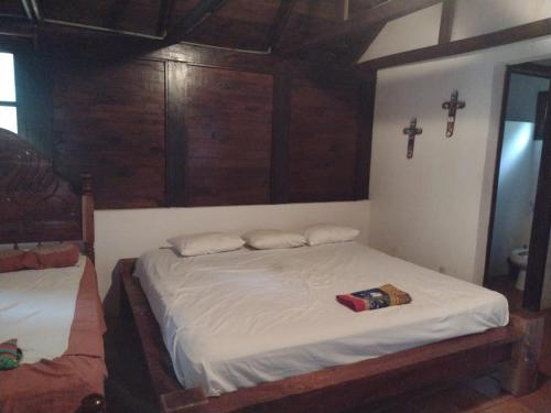 1 dormitorio con 2 camas y una cruz en la pared en Centro ecoturistico Arco del Tiempo, en Cintalapa de Figueroa