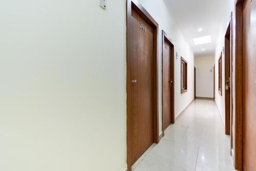 a corridor of a hospital with wooden doors at Hotel O Sabtera Homes in Kharar