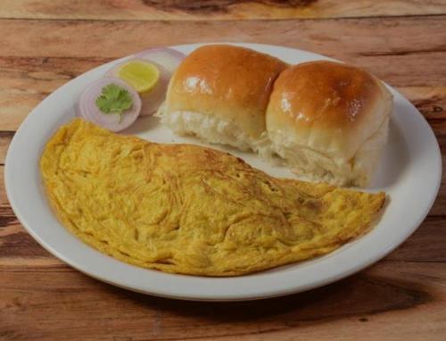 a plate with two breakfast buns and an omelet at Royal Dormitory in Mumbai