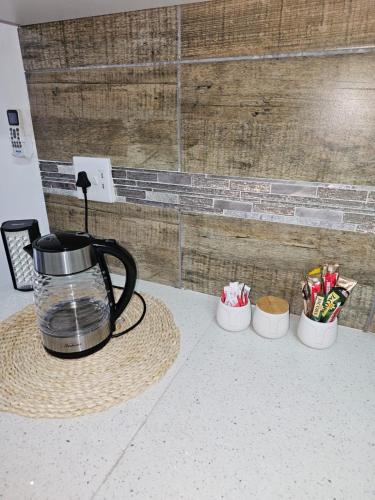 a coffee pot and three cups on a counter at Déjàvu at the Bay in Richards Bay