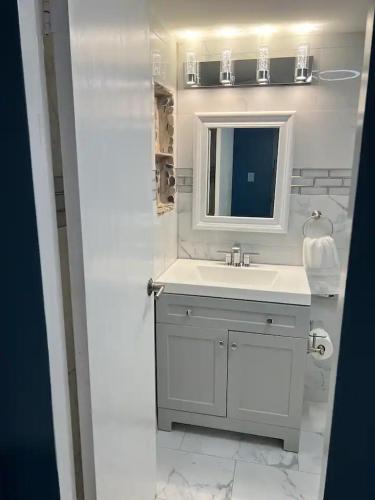 a white bathroom with a sink and a mirror at Entire Condo in Sunny Isles in Sunny Isles Beach