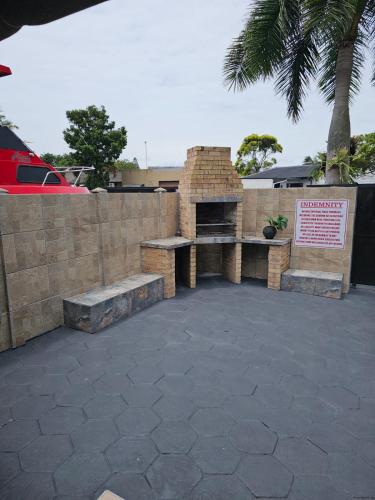 a brick retaining wall with a bench and a sign at Déjàvu at the Bay in Richards Bay