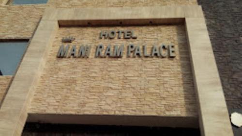 una torre del reloj con las palabras del palacio del hotel en ella en Hotel Mani Ram Palace Agra, en Agra