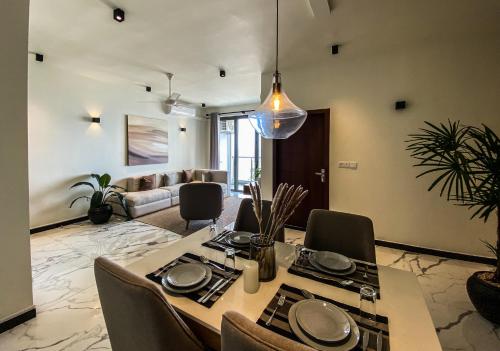 a dining room with a table and chairs and a couch at Marine Breeze Residencies in Colombo