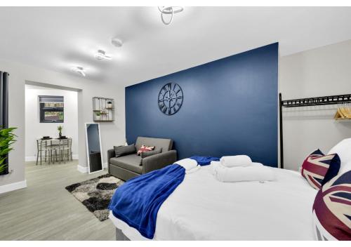 a bedroom with a large bed with a blue wall at Explorer’s Studio - Comfort, Peace, Convenience in London