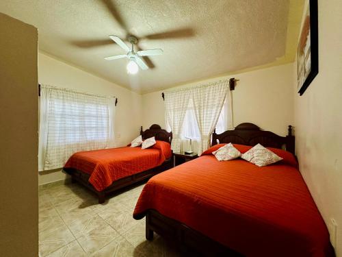 特拉爾普哈瓦德拉永的住宿－Hotel Monarca Tlalpujahua，一间卧室配有两张床和吊扇