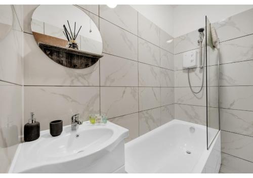 a white bathroom with a sink and a mirror at Green Haven Sleeps Two in London