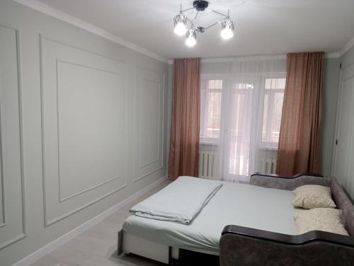 sypialnia z łóżkiem i oknem w obiekcie Orda w Kyzyłordzie