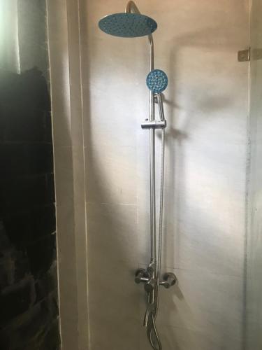 a shower with a blue shower head on a wall at Sapa Hillcrest homestay in Lao Cai