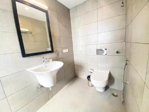 a white bathroom with a sink and a toilet at Hotel Orchid INN at Budget Bazaar Janakpuri in New Delhi