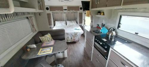 冈尼达RV Caravan in Rural Setting on Edge of Town close to AgQuip的小房间,设有床铺和厨房