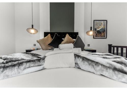 1 dormitorio con 1 cama blanca grande con sábanas de piel en Gorgeous Home VERY Close to the Fast Tube! en Londres