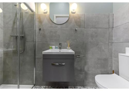 a bathroom with a toilet and a sink and a mirror at Gorgeous Home VERY Close to the Fast Tube! in London