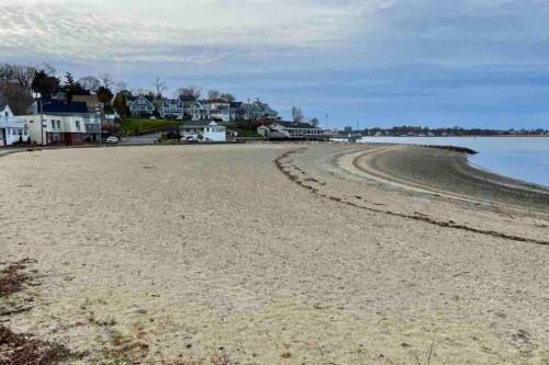 a view of a beach with houses in the background at Cozy Weymouth cottage, walk to beach in Weymouth