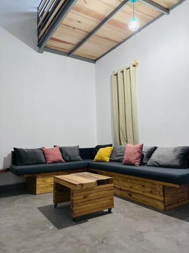 a living room with a black couch and a table at Casa De Campo Mirador H&L in San Antonio de las Alzanas