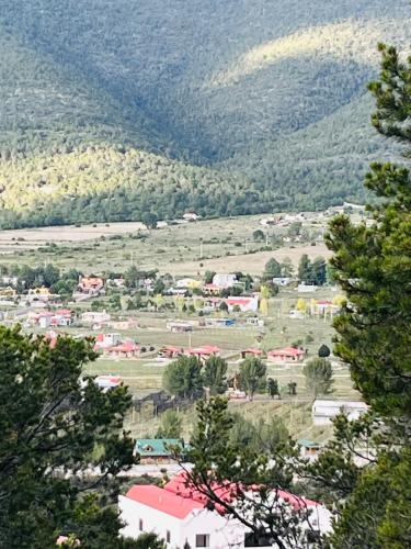 a small town in a field with mountains in the background at Casa De Campo Mirador H&L in San Antonio de las Alzanas