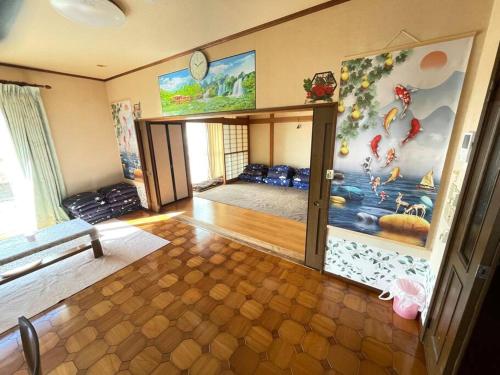 a room with a room with a wall with a mural at 草津温泉、スキー場、湯畑、熱帯圏車で5分以内！最大27人宿泊可能 in Kusatsu