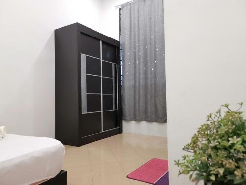 1 dormitorio con 1 cama y armario negro en Cosy 19 white house@Bukit Mertajam, Alma penang en Bukit Mertajam