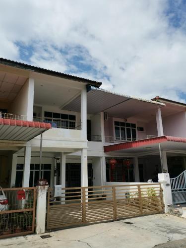 une grande maison avec une clôture devant elle dans l'établissement Cosy 19 white house@Bukit Mertajam, Alma penang, à Bukit Mertajam