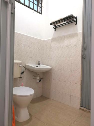 La salle de bains est pourvue de toilettes et d'un lavabo. dans l'établissement Cosy 19 white house@Bukit Mertajam, Alma penang, à Bukit Mertajam