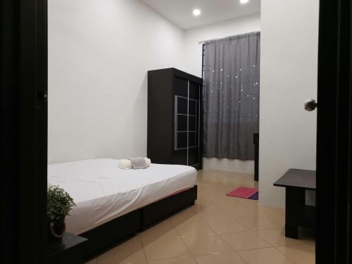 a bedroom with a bed and a black cabinet at Cosy 19 white house@Bukit Mertajam, Alma penang in Bukit Mertajam