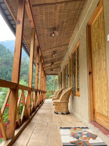 a porch of a building with a view of the mountains at Living Good - A Himalayan Boutique Stay in Gushaini