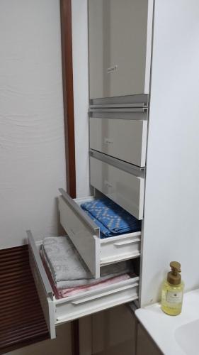 einen Kühlschrank mit offenen Türen und Handtüchern in der Unterkunft Haruka 紫 in Naha