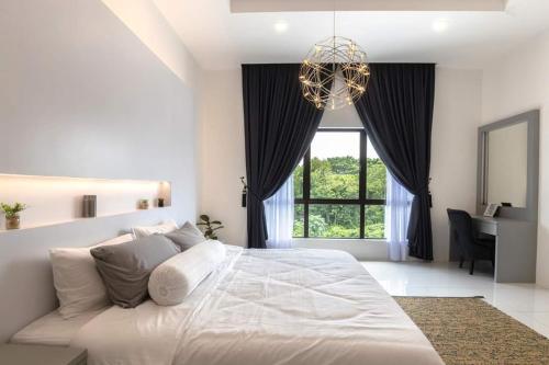 a white bedroom with a large bed and a chandelier at Ayu Homestay in Klang