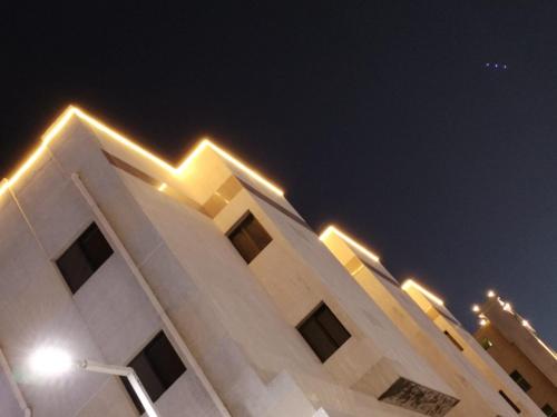 a building with lights on top of it at night at الساعه 60 الفندقيه in Dammam