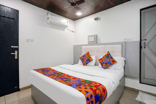 FabHotel Park Residency في مومباي: غرفة نوم بيضاء مع سرير مع لحاف ملون