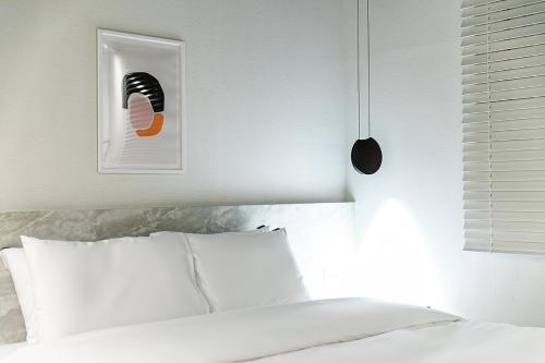 a bedroom with a white bed and a picture on the wall at Hotel Yaja Masan Odong Branch in Changwon