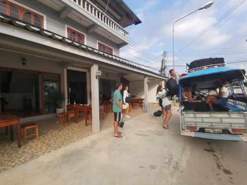 a group of people standing outside of a building at Manilath guesthouse in Ban Houayxay