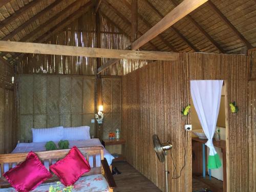 Phumĭ Kaôh Ândêt的住宿－Tatai Natural Resort，一间卧室配有带粉红色枕头的床