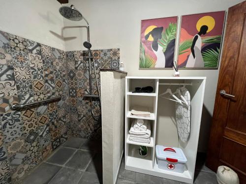 baño con ducha y estante con toallas en Casa Vulcania en La Rosa