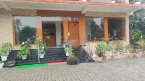 um edifício com vasos de plantas à sua frente em Tierra Hotel Kohora em Kaziranga
