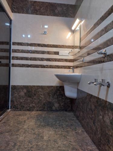 une salle de bain avec un lavabo et une douche dans l'établissement Isha Marari Beach homestay, à Mararikulam