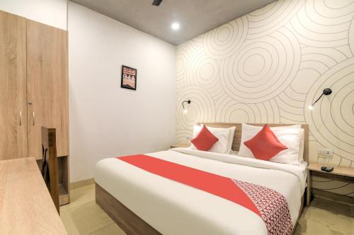 um quarto com uma cama grande e almofadas vermelhas em Collection O Jps Grand Hotel Near Dwarka Metro Station em Nova Deli