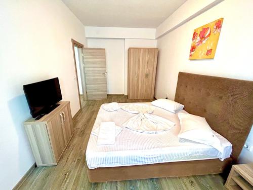a small bedroom with a bed and a tv at Summerland Seaview Apartments in Mamaia