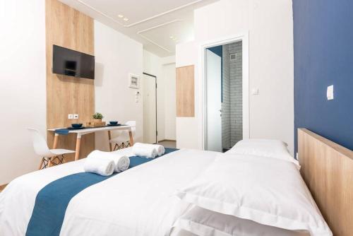a bedroom with a large bed with towels on it at Pantheon square view 2 in Komotini