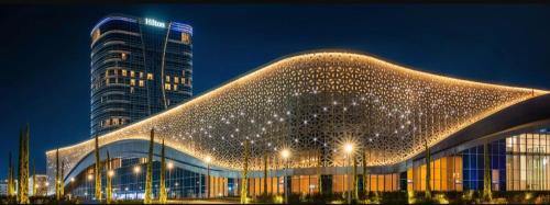 um grande edifício com luzes de Natal em frente a um edifício alto em APARTMENT «СЕМЬЯ» em Tashkent