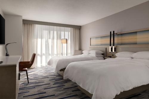 a hotel room with two beds and a desk at Marriott Saddle Brook in Saddle Brook