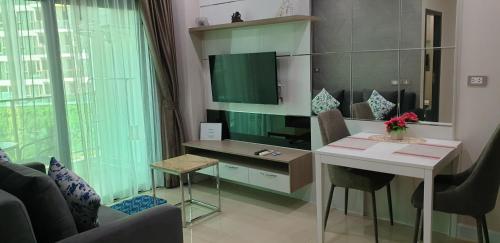 a living room with a desk and a table with chairs at Dusit Grand Condo View Apartment in Jomtien Beach