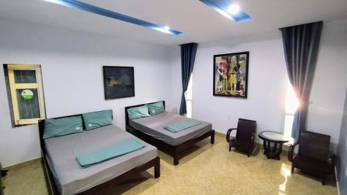 a bedroom with two beds and a table and chairs at Q' Homestay Garden Villa in Hue